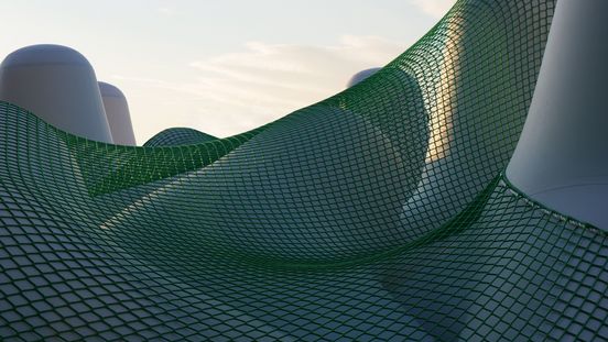Foto: Blick auf weiße Tetrapoden, die teilweise durch ein grünes Netz miteinander verbunden sind.