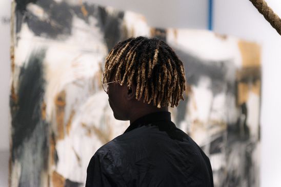 Photo: Visitor in front of a work of art, looking at the exhibit.