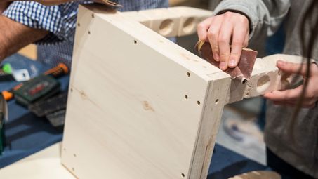Selbstgemachter Holzstuhl, der weiter bearbeitet wird
