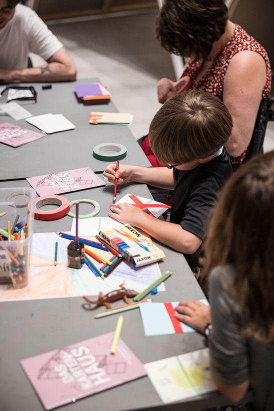 Photo: An adult and children sit at a table and do handicrafts.