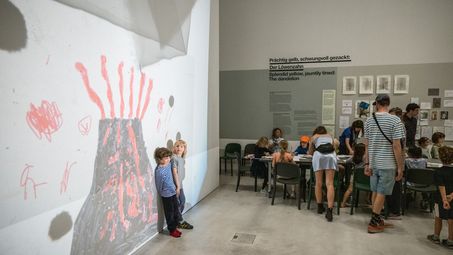 Kinder, die vor einer großen selbstgemalten Projektion an der Wand stehen