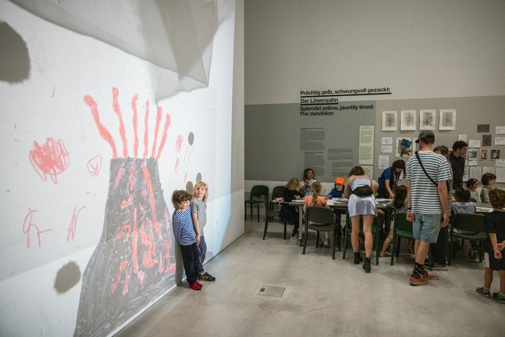 Kinder, die vor einer großen selbstgemalten Projektion an der Wand stehen