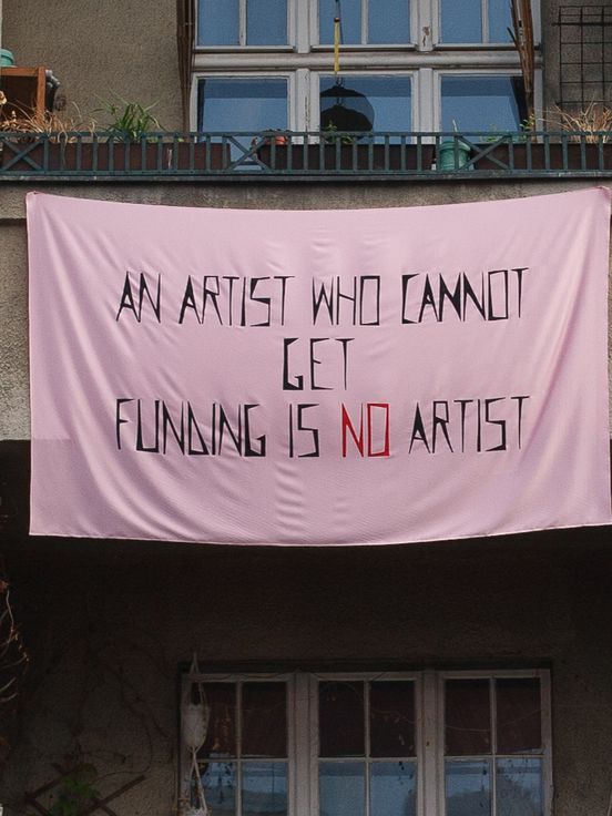 Vlad Brăteanu , „an artist who cannot get funding is no artist“, public intervention on Dudenstrasse 15, Berlin, June 2021, after Mladen Stilinović and Anca Benera and Arnold Estefan, 2021, acrylic on artificial silk, 153 x 253 cm