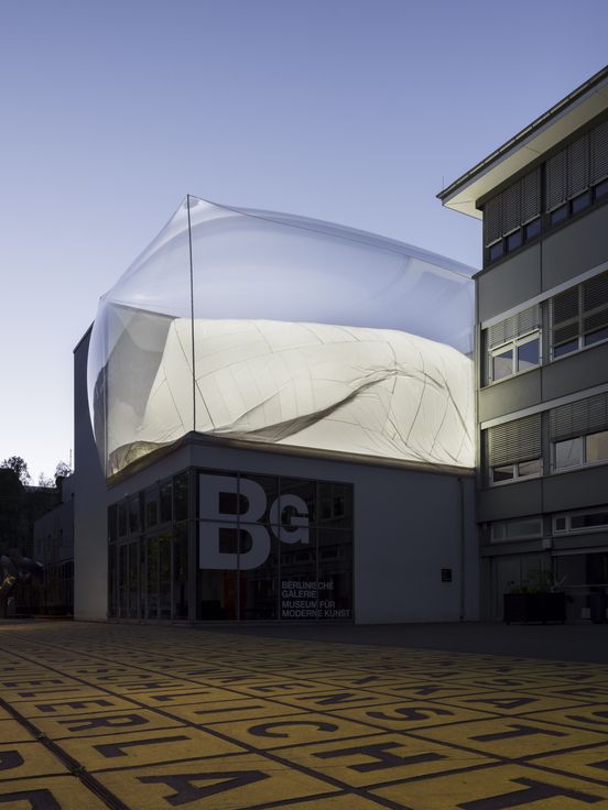 Außenansicht der Berlinischen Galerie bei Abenddämmerung mit einer Installation auf dem Dach
