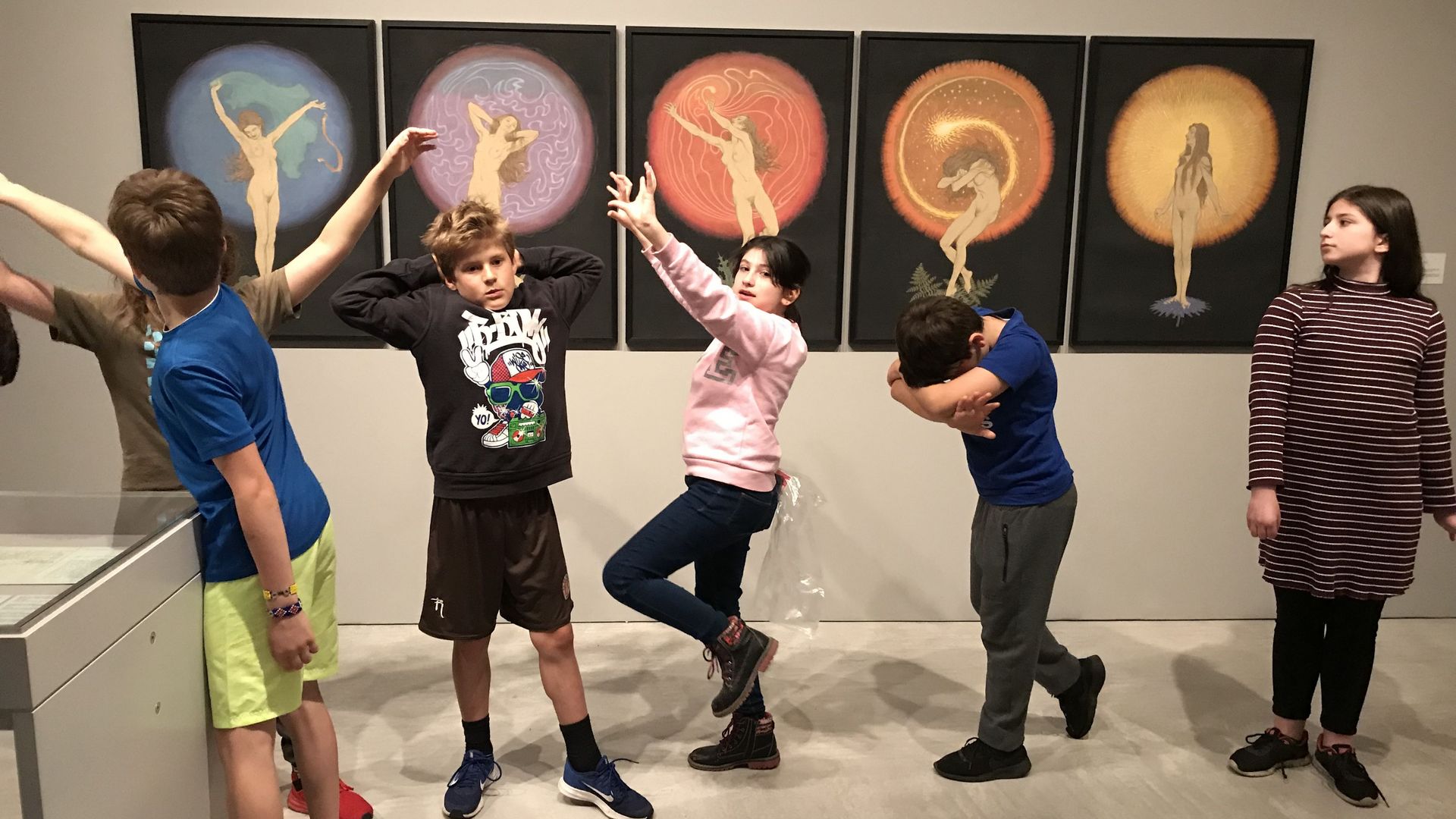 Foto: Kinder stehen vor fünf Kunstwerken und ahmen die Haltungen der abgebildeten Figuren nach.