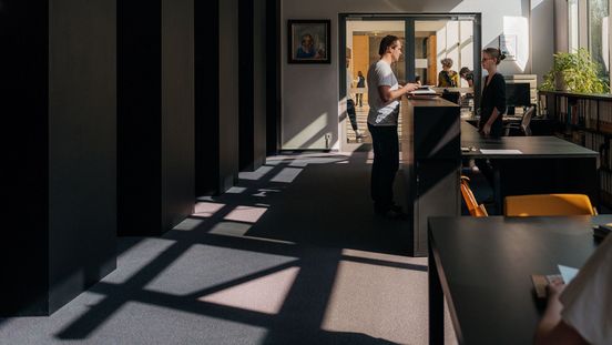 Foto: Besucher am Tresen der Bibliothek.