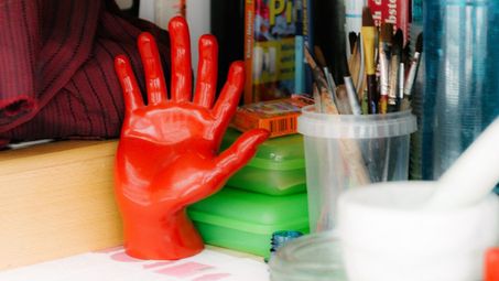 Photo: A shelf with books, brushes and other materials.