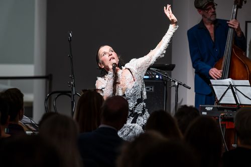 Meret Becker Foto: Meret Becker mit gestikulierendem Arm während sie singt.