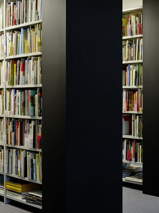 Photo: Parallel floor-to-ceiling shelves with books.