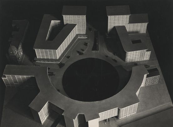 Black-and-white photograph of a model showing a roundabout at Berlin’s Alexanderplatz, surrounded by multi-storey buildings with uniform façade design.