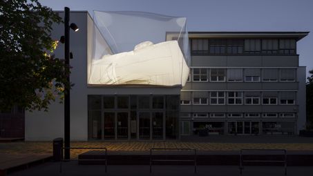 Außenansicht der Berlinischen Galerie bei Abenddämmerung mit einer Installation auf dem Dach